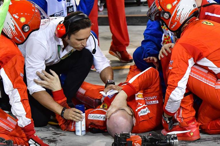 Mecânico da Ferrari recebe atendimento após ser atropelado por Kimi Raikkonen durante o GP do Bahrein
