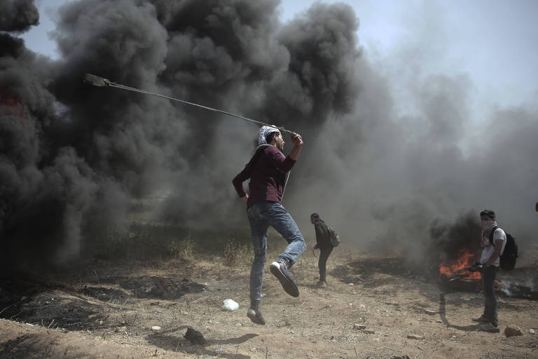 Manifestantes palestinos enfrentam soldados israelenses durante protesto perto da fronteira de Gaza com Israel
