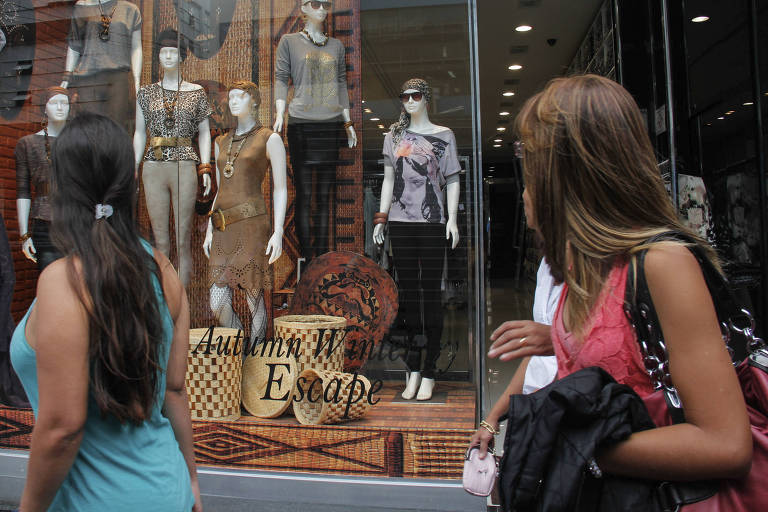 Consumidoras olham vitrine de loja no Brás (SP)