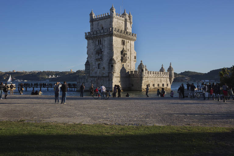 Turistas visitam a Torre de Belém, às margens do rio Tejo, em Lisboa