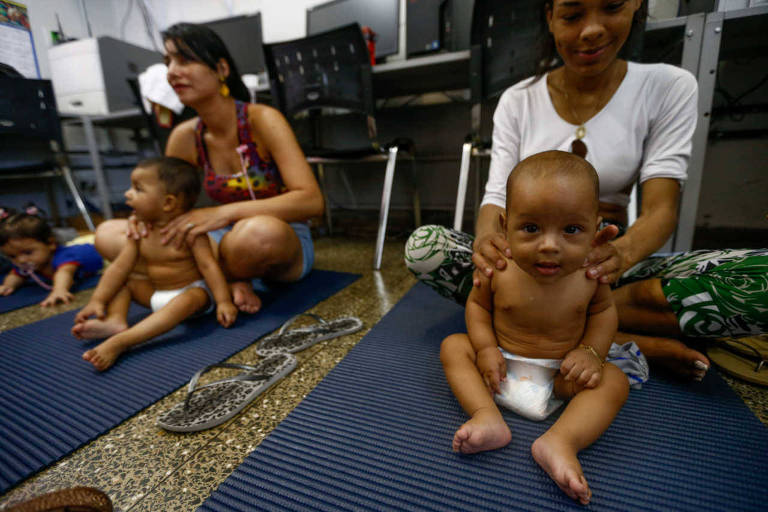 Em posto de saúde de Brasília, mães aprendem a fazer em seus bebês a shantala, prática de massagem originária da Índia; na foto, mães massageiam os bebês, sentados em esteiras