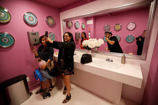 Guests take a selfie during a VIP media preview ahead of the opening of The Museum of Selfies in Glendale