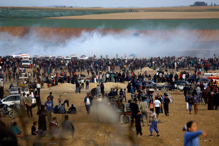Manifestantes palestinos durante confronto com tropas israelenses na fronteira