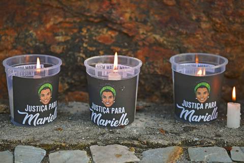 Burning candles at a vigil mourning activist Marielle Franco, one month after her murder on Ipanema beach, April 14, 2018. 
The murder of Franco, a black Brazilian activist who fought her way out of the slums to become a popular councilor, made headlines around the world. The outspoken 38-year-old, who was a critic of police brutality, an advocate for minorities and the posterchild of a new type of politics, was shot dead on March 14 in an assassination-style killing with four bullets to the head. / AFP PHOTO / CARL DE SOUZA ORG XMIT: 586