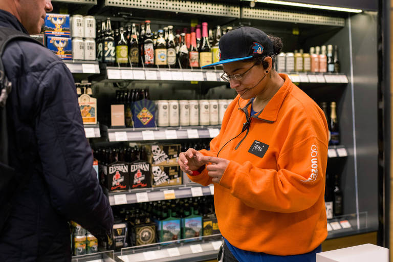 Uma funcionária checa das identidades na seção de bebidas alcoólicas na loja da Amazon Go