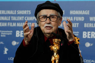 FILE PHOTO: Director Vittorio Taviani gestures behind the Golden Bear award for the best film 'Caesare Deve Morire' ('Caesar Must Die') during a news conference after the awards ceremony of the 62nd Berlinale International Film Festival in Berlin