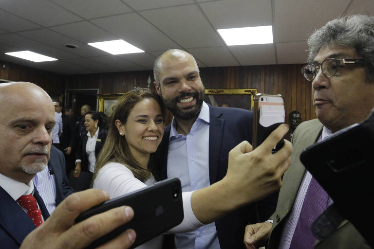 Jovem faz selfie ao lado do prefeito Bruno Covas em encontro com vereadores na Câmara Municipal de SP