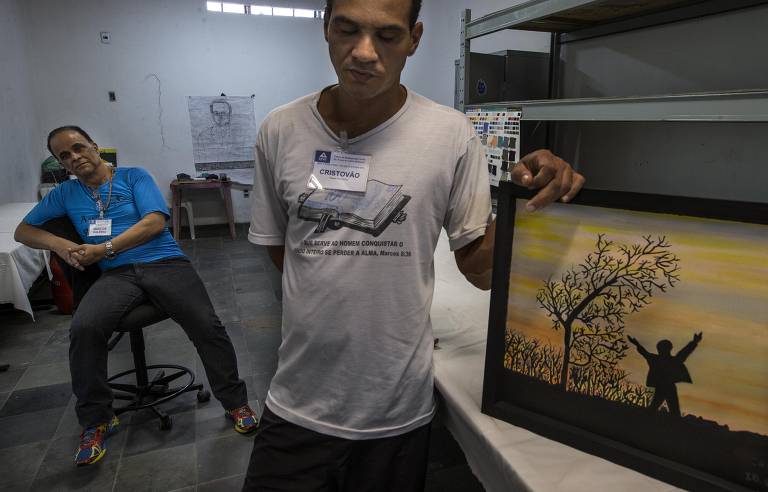 Um dos alunos de pintura de Marcos Valério na Apac mostra um quadro pintado com assistência do publicitário