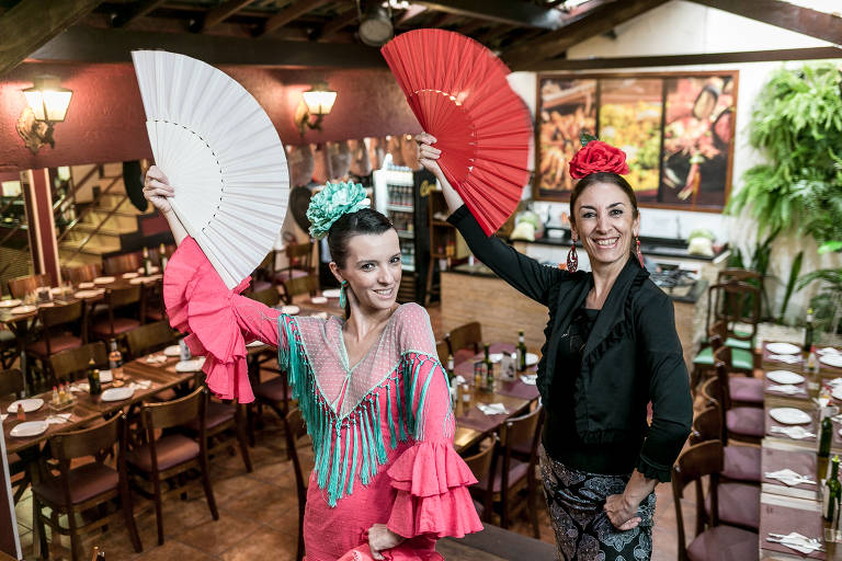 Duas dançarinas de flamenco seguram leques nas mãos