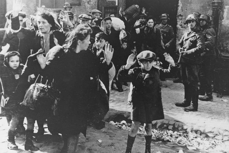 Em gesto tornado célebre, menino levanta os braços diante de soldados alemães no gueto de Varsóvia, em 1943, durante a Segunda Guerra Mundial