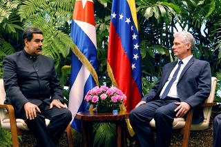 Cuban President Miguel Diaz-Canel speaks to Venezuela's President Nicolas Maduro at the Revolution Palace in Havana