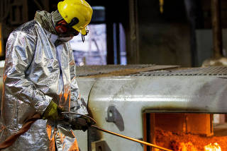 An enployee works in the Brazilian steelmaker Usiminas blast furnace after a long shutdown, in Ipatinga