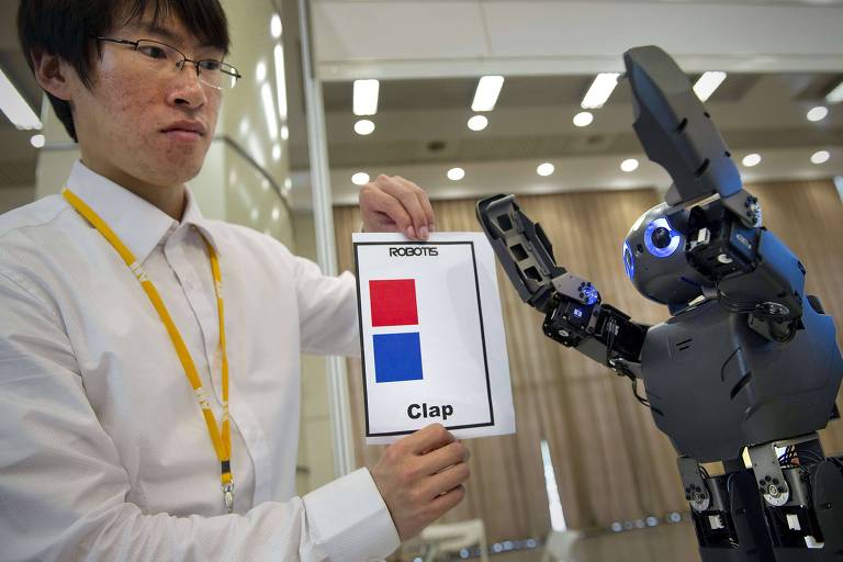 Funcionário opera robô em demonstração sobre capacidades de reconhecimento durante conferência em Xangai, na China