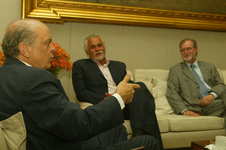 Prefeito de São Paulo, José Serra, se reúne com o presidente do PT, Jose Genoino, no gabinete da prefeitura, acompanhado por Eduardo Azeredo; esquema operado por Marcos Valério em Minas é descoberto neste ano em meio ao escândalo do mensalão do PT