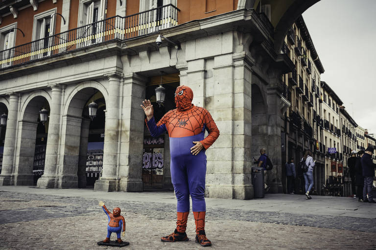 Artista fantasiado de Homem-Aranha que pede contribuições aos pedestres na praça Maior, retratada em ‘A Flor do Meu Segredo’ (1995)