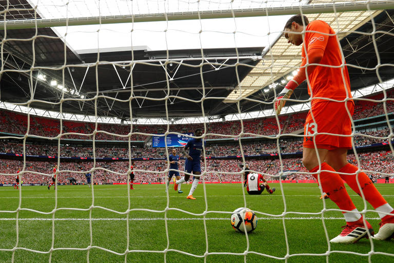 Goleiro tira a bola de dentro do gol no estádio de Wembley, na Inglaterra