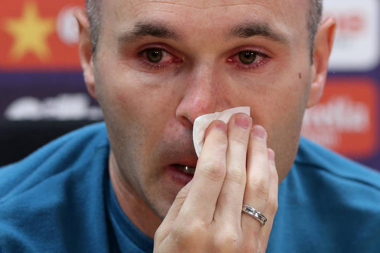 Iniesta chora e limpa nariz com um lenço durante entrevista coletiva em que anunciou a saída do Barcelona