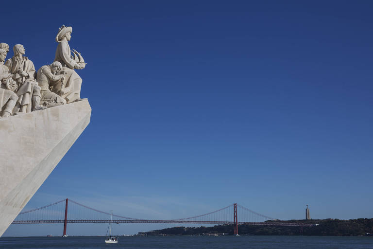 monumento de mármore branco é uma estátua em que figuras humanas olham em direção ao oceano