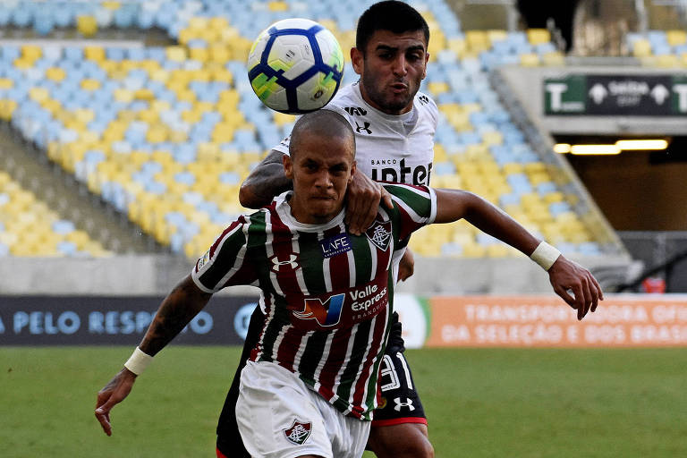 O volante Liziero, do São Paulo, tenta tirar a bola do atacante Marcos Júnior, do Fluminense, em duelo no Maracanã
