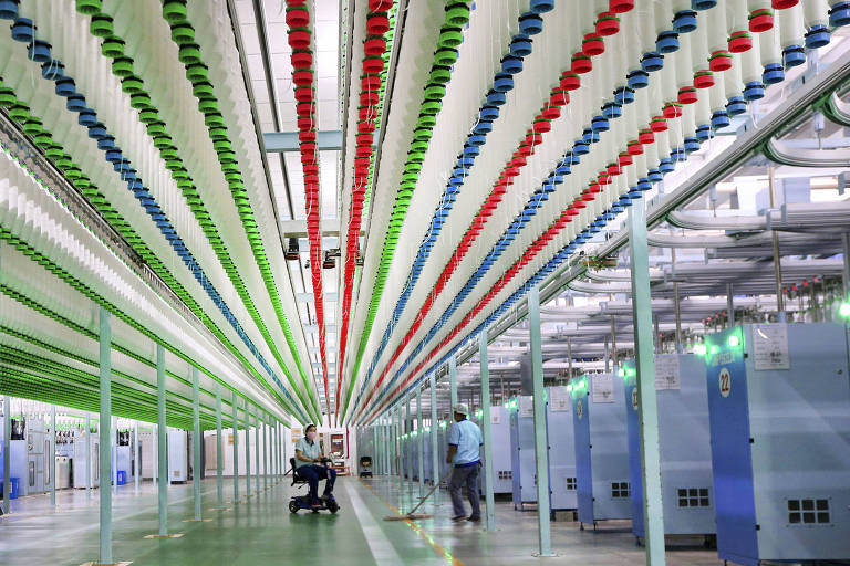 Trabalhadores em linha de produção de fábrica têxtil em Nantong, na China