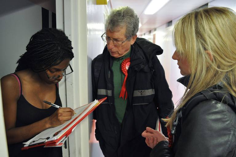 A estudante Shakira Elysses-Bryden (esq.) recebe os conselheiros locais Claire Gilbert e Jeremy Ambache, do Partido Trabalhista, durante a campanha em Wandsworth, no sul de Londres 
