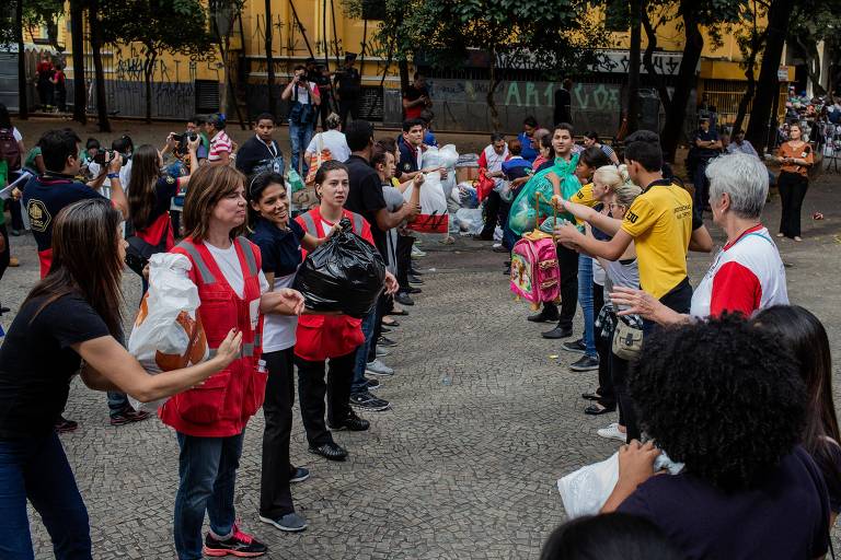 Voluntários fazem fila para distribuir doações aos desabrigados no Largo do Paissandu, região central de São Paulo