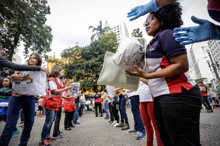 Voluntários fazem fila para distribuir doações aos desabrigados no Largo do Paissandu, região central de São Paulo  