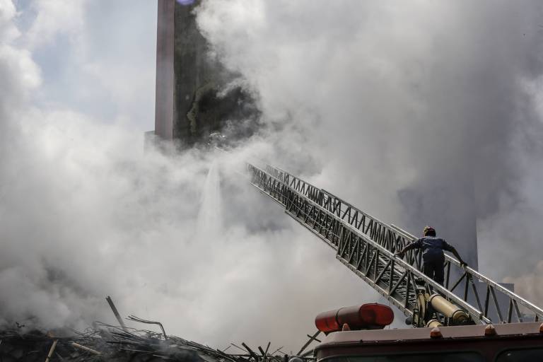 Bombeiro trabalha nos escombros de prédio que desabou após ser atingido por incêndio de grandes proporções no largo do Paissandu, região central de São Paulo