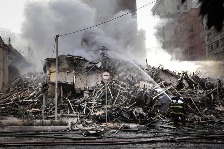 Bombeiro trabalha nos escombros de prédio que desabou após ser atingido por incêndio de grandes proporções no largo do Paissandu, região central de São Paulo
