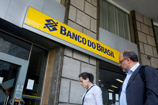 People walk in front of a Banco do Brasil branch in downtown Rio de Janeiro