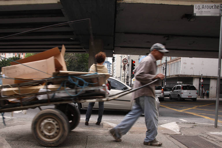 Homem puxa carroça pela região central de São Paulo