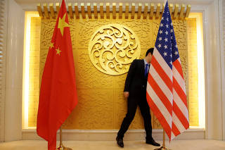 A staff member sets up Chinese and U.S. flags for a meeting during a visit by U.S. Secretary of Transportation Elaine Chao at China's Ministry of Transport in Beijing