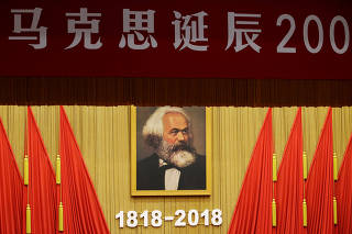A portrait depicting Karl Marx is seen at an event commemorating the 200th birth anniversary of the German philosopher, in Beijing
