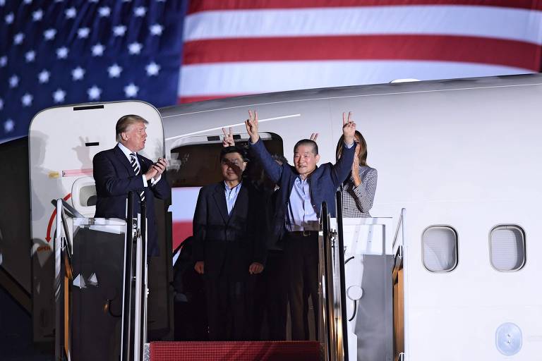 Kim Dong-chul, um dos libertados, acena ao deixar o avião ao lado do presidente Donald Trump e da primeira-dama, Melania 