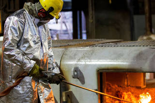 An enployee works in the Brazilian steelmaker Usiminas blast furnace after a long shutdown, in Ipatinga