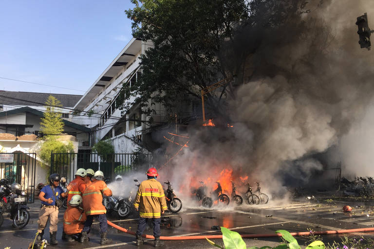 Bombeiros tentam extinguir incêndio após ataque terrorista em igreja pentecostal em Surabaya, na Indonésia
