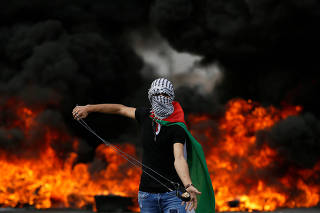 Palestinian demonstrator holds a sling during a protest marking the 70th anniversary of Nakba, near the Jewish settlement of Beit El, near Ramallah, in the occupied West Bank