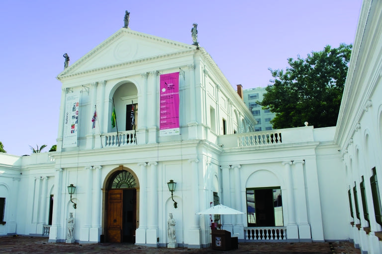 Exterior do Museu da Casa Brasileira; é uma casa em U, que tem um segundo andar sobre sua entrada central; é branca, em estilo neoclássico, com um frontão, pilastras e arcos