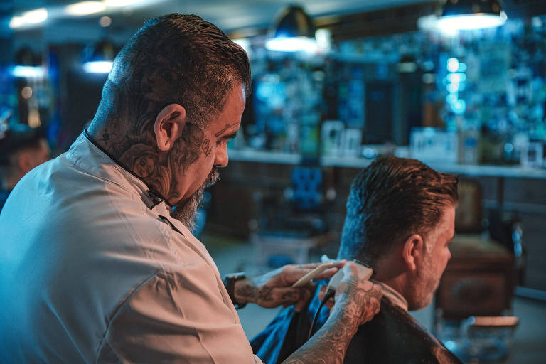 O proprietário da Barbearia Cavalera, Mario Pinheiro de Andrade, corta o cabelo de um cliente