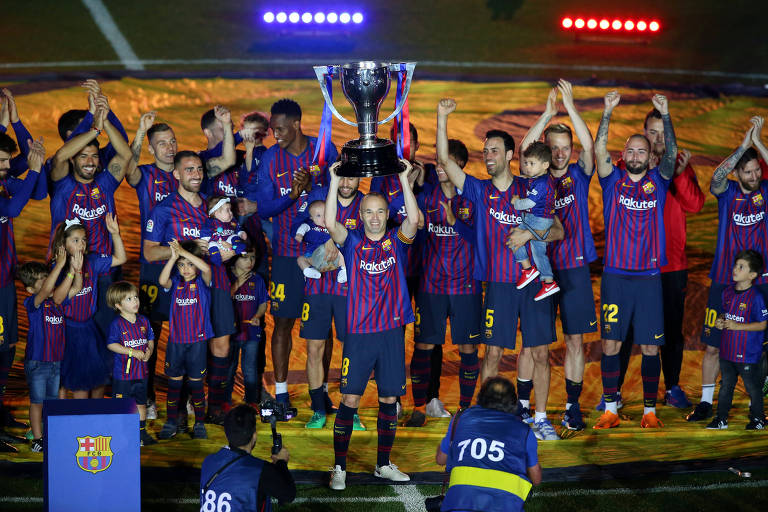Iniesta levanta troféu depois de ter conquistado por antecipação o título de campeão espanhol 
