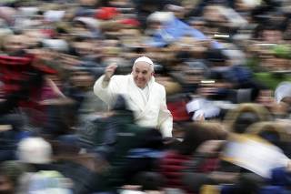 Pope Francis waves as he arrives to conduct his weekly general audience at St. Peter's Square at the Vatican