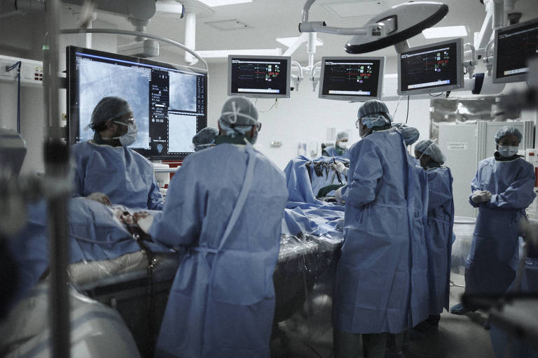 Vários médicos aparecem em volta de uma mesa de cirurgia no Hospital Israelita Albert Einstein.