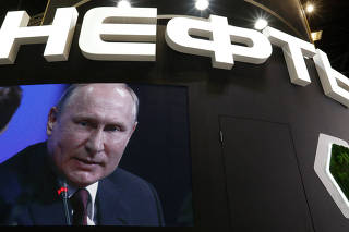 Russian President Putin is seen on a screen at the stand of Russian state oil major Rosneft during the St. Petersburg International Economic Forum