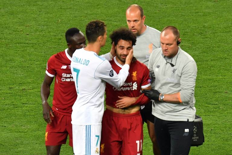 O jogador egípcio Mohamed Salah recebe abraço de Cristiano Ronaldo ao sair de campo após se machucar em falta
