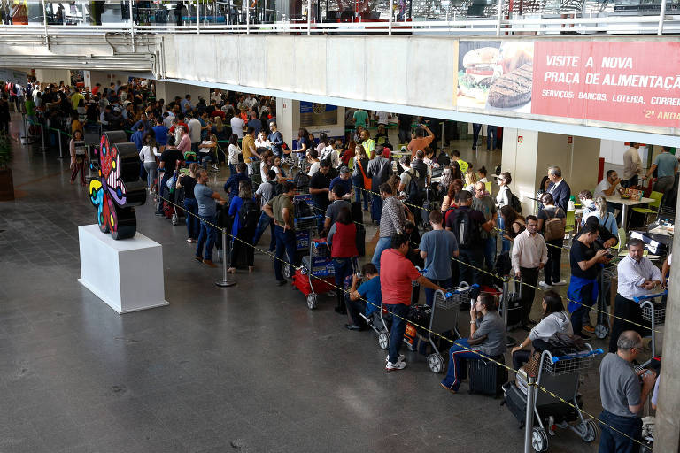Passageiros que tiveram voos cancelados esperam em fila para acomodação em hotéis ou em outros voos no aeroporto de Brasília