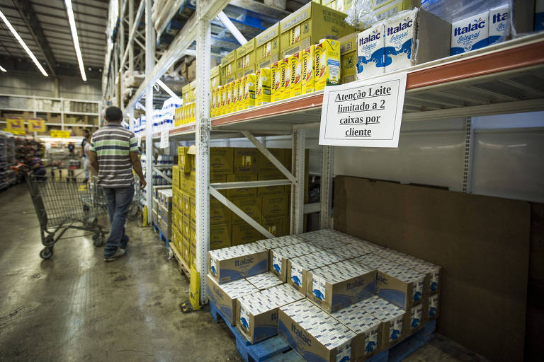 Gôndola de supermercado durante paralisação dos caminhoneiros com caixas de leite e cartaz com os dizeres "Venda de leite limitada a duas caixas por pessoa"