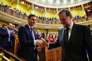 Spain's new Prime Minister and Socialist party (PSOE) leader Pedro Sanchez shakes hands with ousted Prime Minister Mariano Rajoy after a motion of no confidence vote at parliament in Madrid
