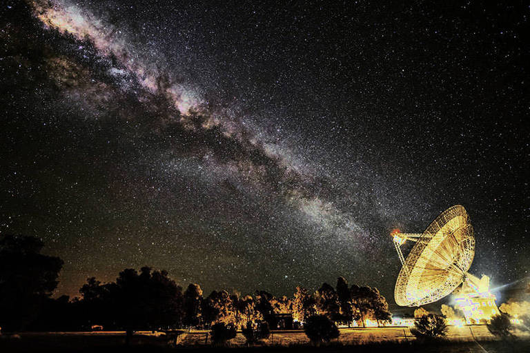 O fotógrafo Wayne England conseguiu capturar o momento quando a Via Láctea parece se alinhar com o telescópio do Observatório Parkes, na Austrália