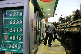 An employee of a gas station prepares to fill a car's tank in Rio de Janeiro