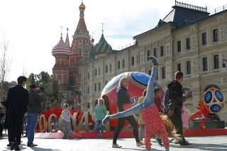 People walk past decorations for the upcoming 2018 FIFA World Cup in central Moscow